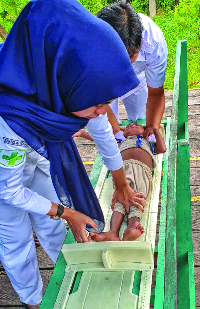 Di titik-titik pembayaran, Dinas Kesehatan Kabupaten Asmat memberikan layanan kesehatan kepada anak-anak penerima dana BANGGA Papua (kanan bawah) Foto : Syaifullah/Yayasan BaKTI