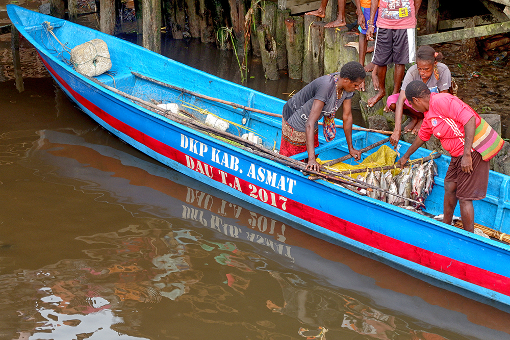 Wanita nelayan Asmat dengan ikan hasil tangkapannya yang siap dijual 