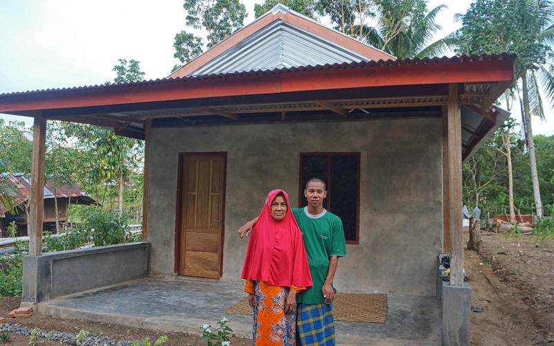 Ibu Sanariah bersama anaknya didepan Rumah baru mereka yang dibangun dengan bantuan UPZ BAZNAS dan warga (Kiri). <br>Foto : Hamsah Sinring/Yayasan BaKTI