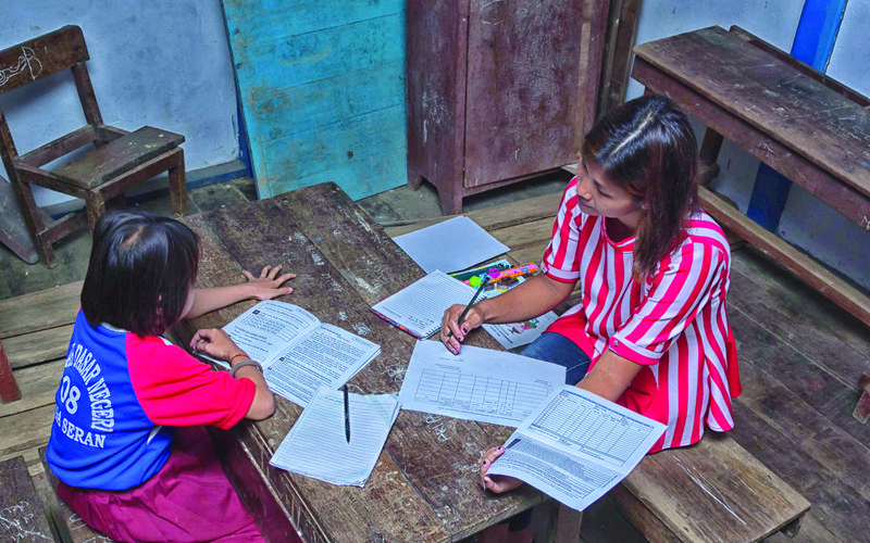 Masyarakat melalukan tes cepat kepada siswa untuk mengetahui kemampuan dasar siswa untuk membaca dan berhitung. <br>Foto: Abdurrahman Doge/TNP2K