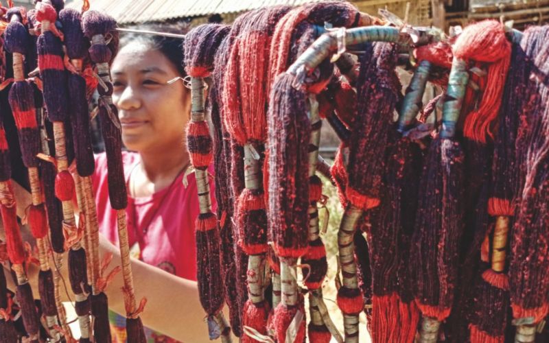 Lusi, penenun muda yang sedang menjemur benang yang diwarnai. Foto: Diana Timoria