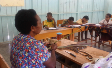 Salah satu Mama Papua terlibat dalam pembelajaran di kelas dengan berbagi cara pembuatan Noken, tas tradisional khas Papua, kepada siswa. Murni Sianturi/The Conversation Indonesia.