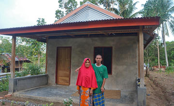 Ibu Sanariah bersama anaknya didepan Rumah baru mereka yang dibangun dengan bantuan UPZ BAZNAS dan warga (Kiri). <br>Foto : Hamsah Sinring/Yayasan BaKTI